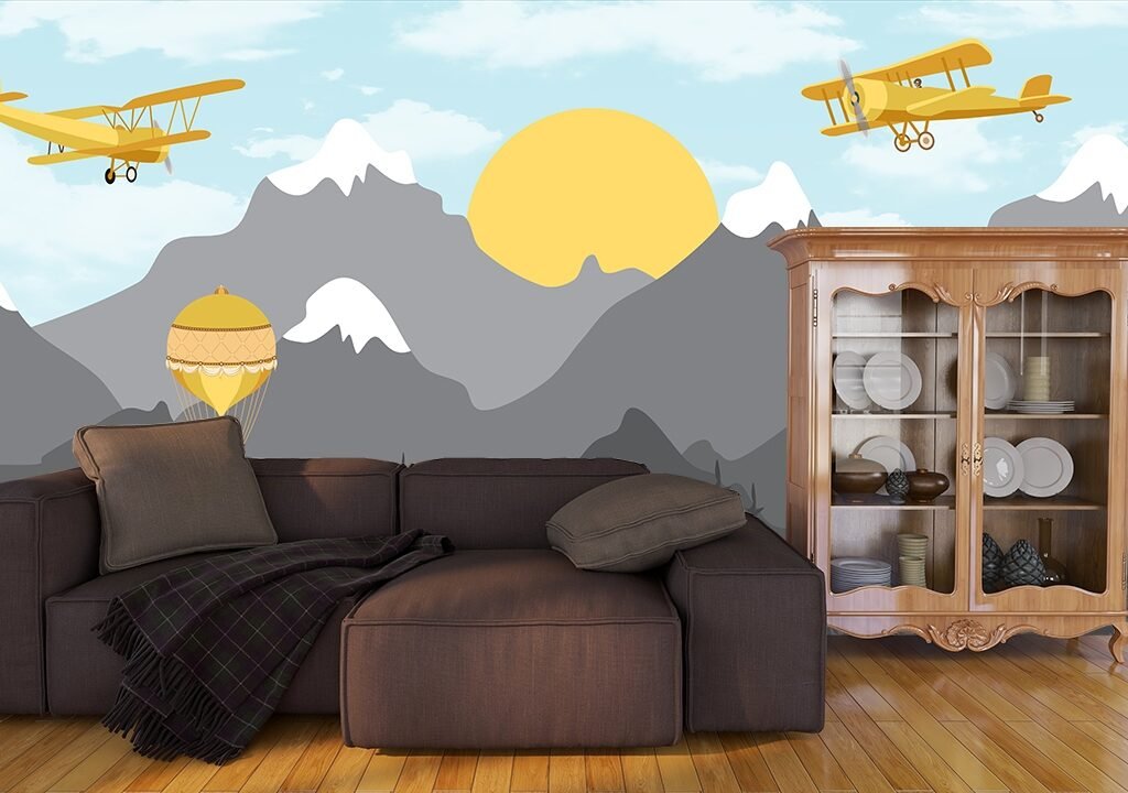 A yellow airplane flying over mountains